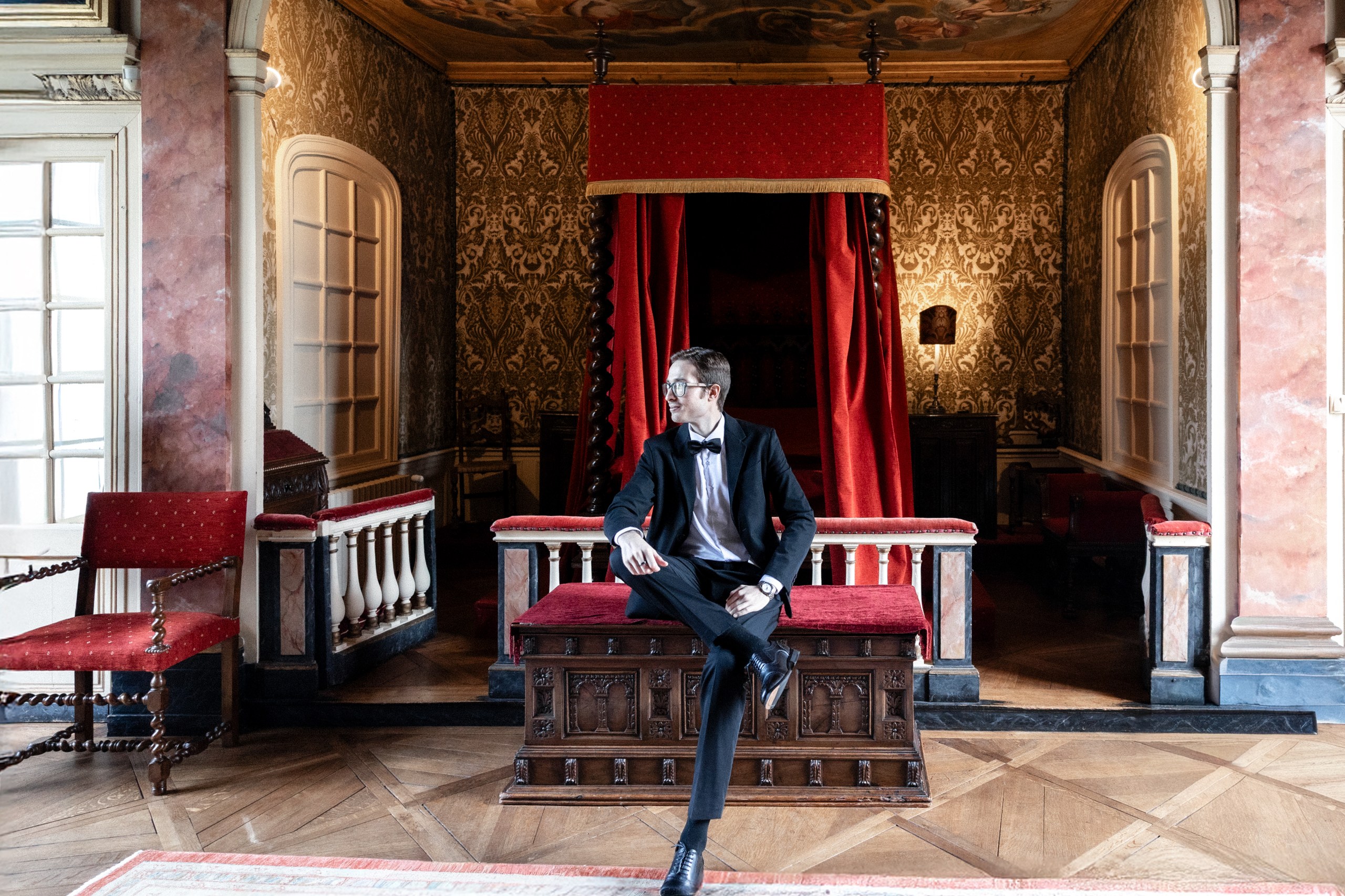 The groom seated in one of the historic-monument rooms at Château de Bonnemare