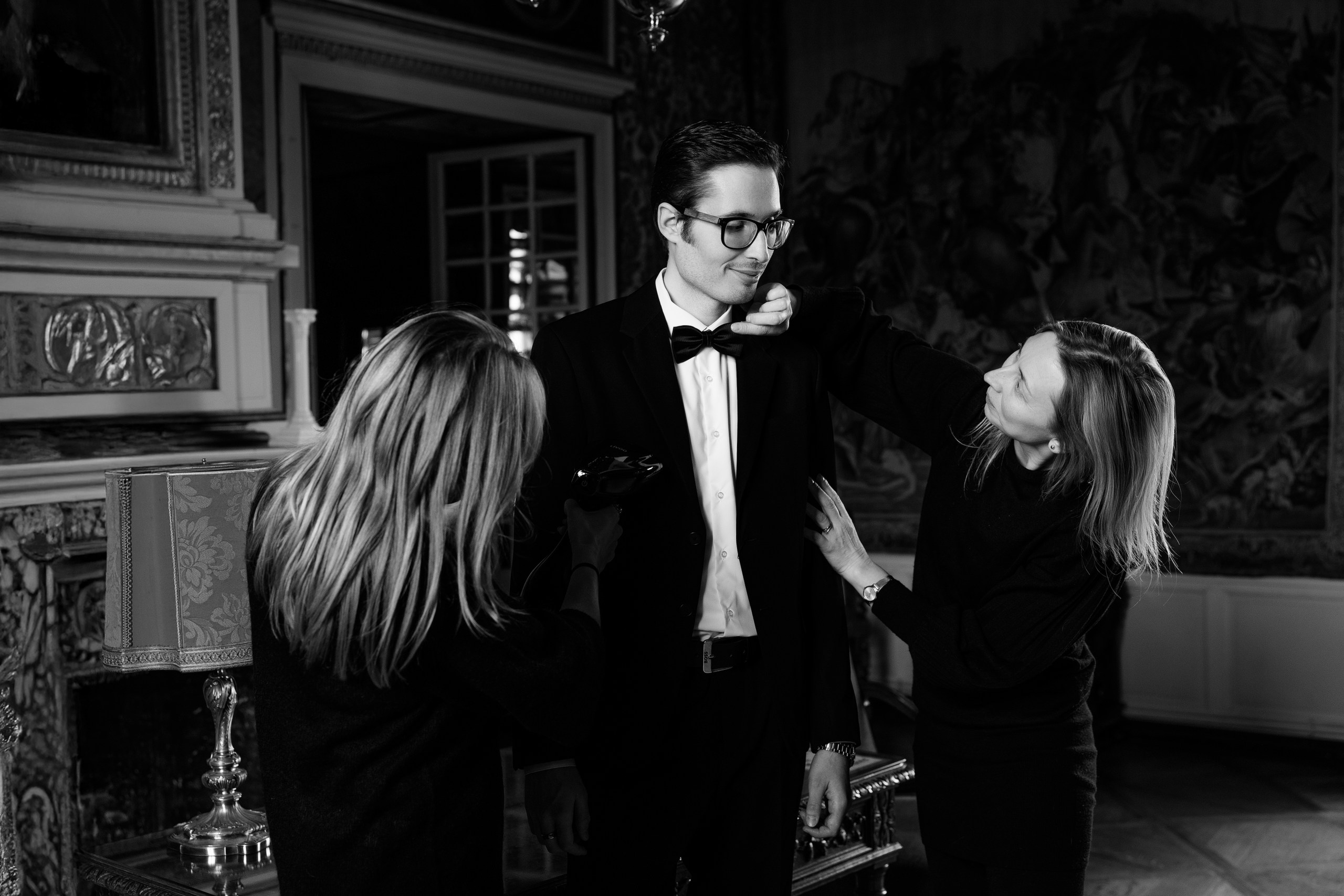 The groom getting ready in front of an antique fireplace at Château de Bonnemare